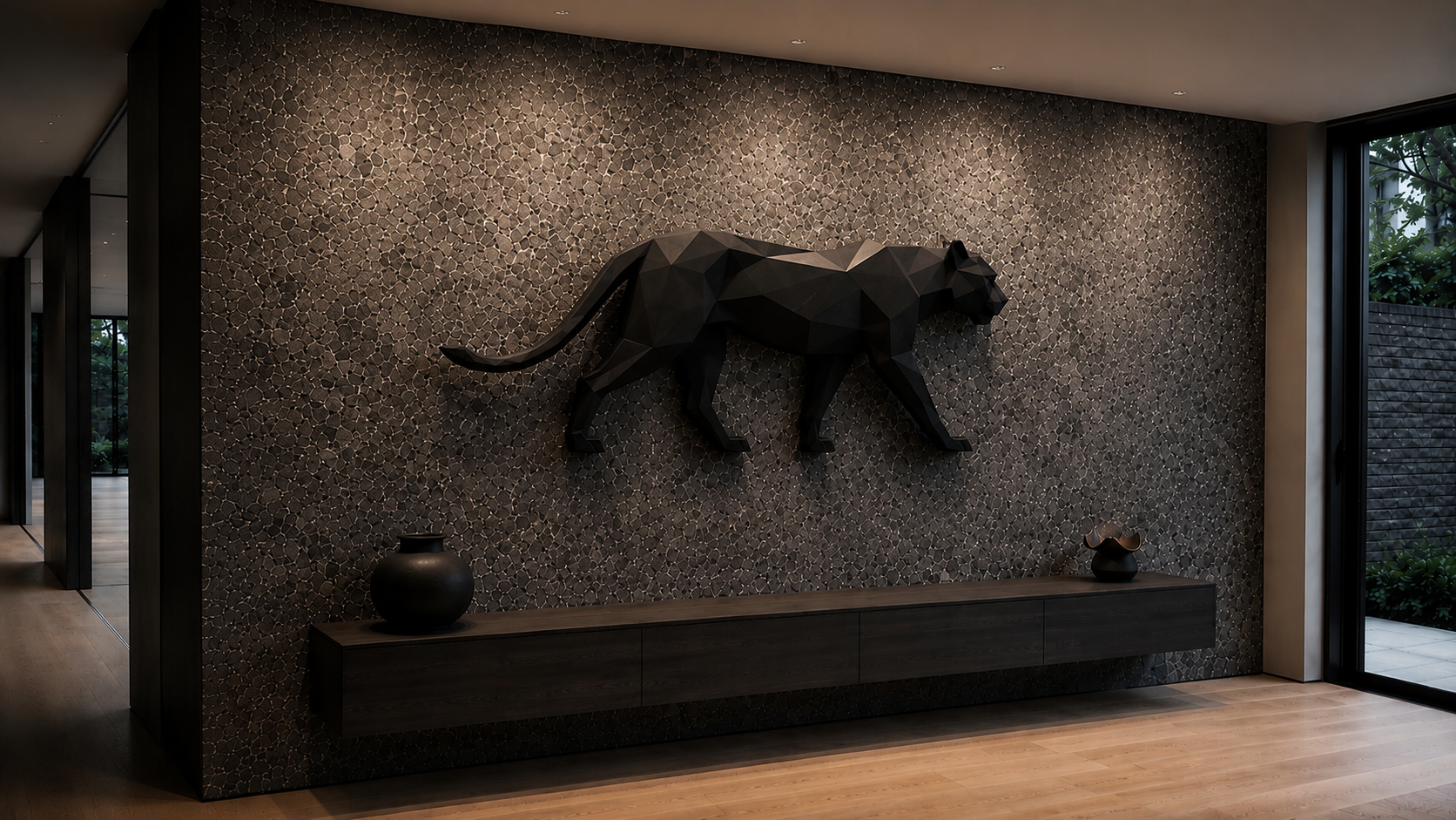 Professional wall washing evenly illuminating a charcoal granite feature wall with a geometric black steel panther sculpture in a contemporary residential interior.