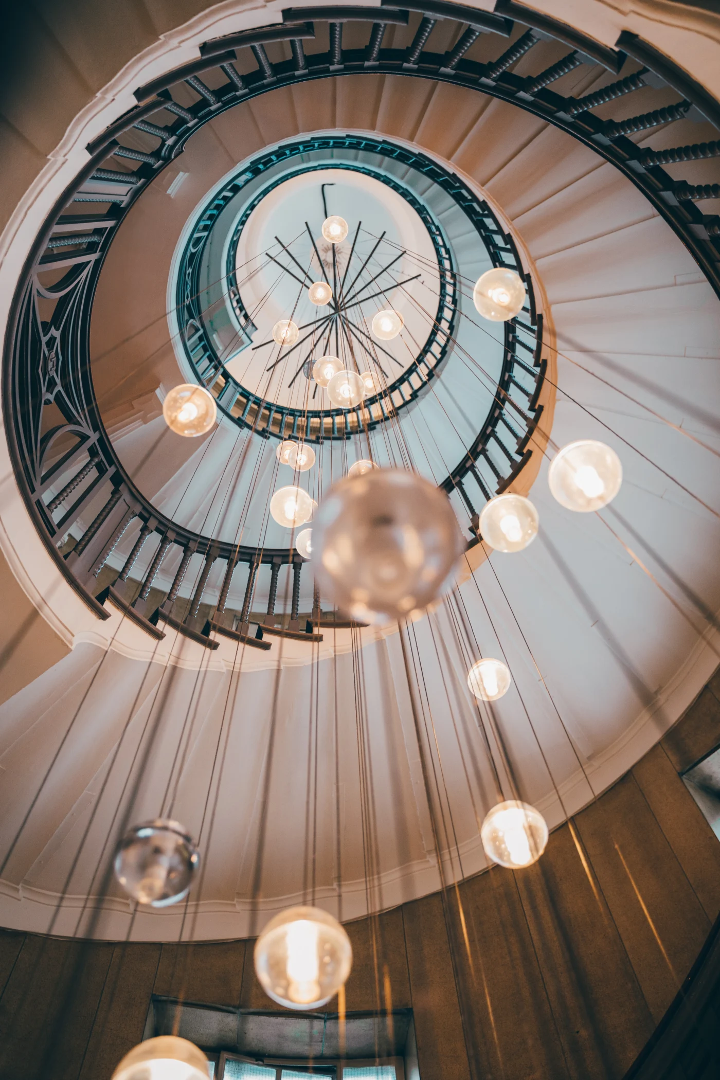 Statement spiral staircase with pendant lighting installation
